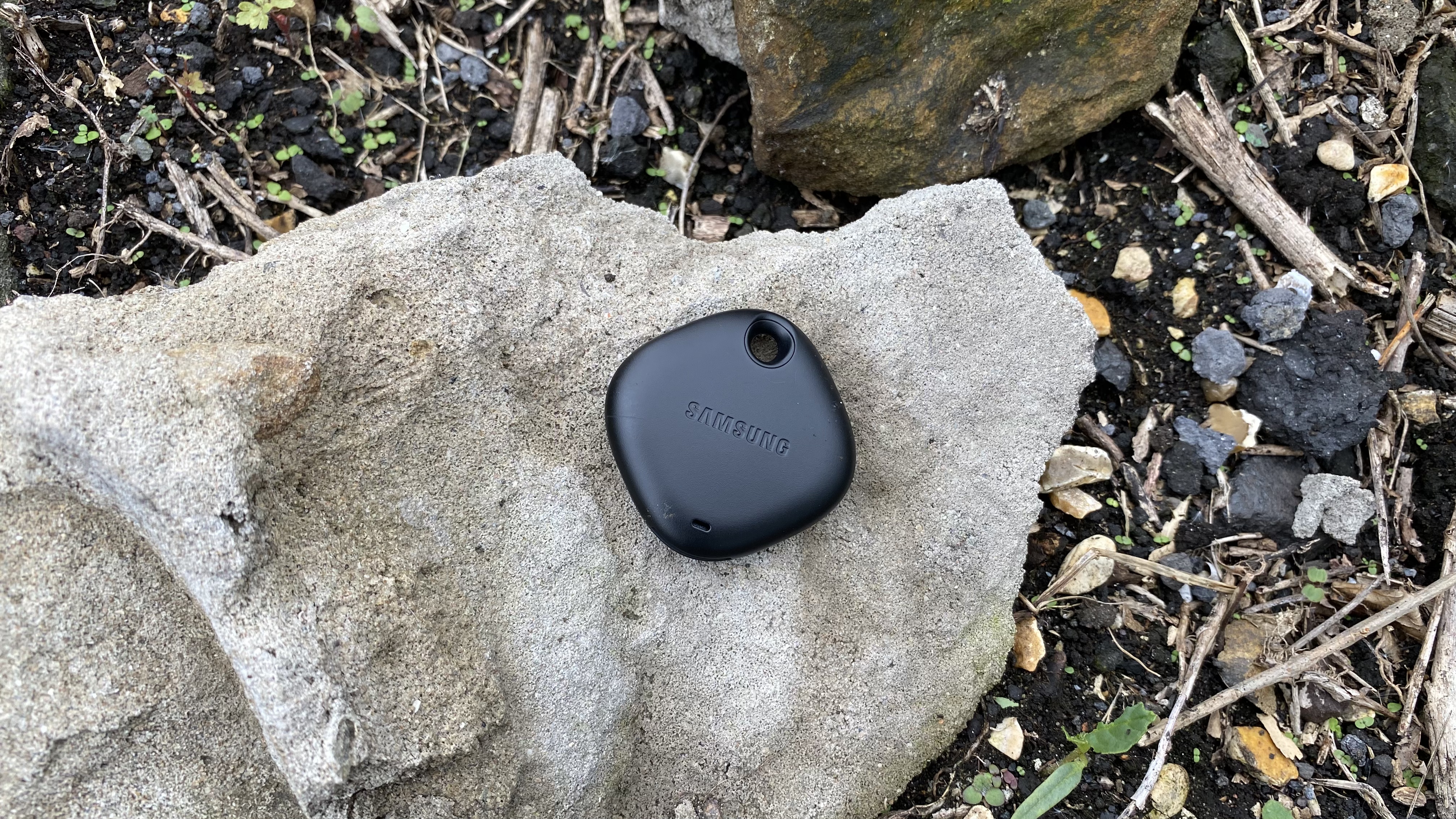 A Samsung Galaxy SmartTag Plus on a rock