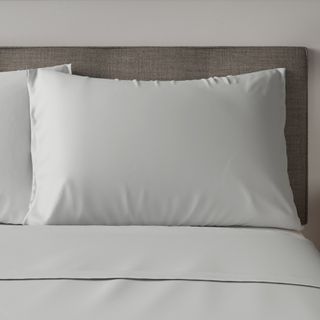 white pillowcase with pillow in bed and room with white wall