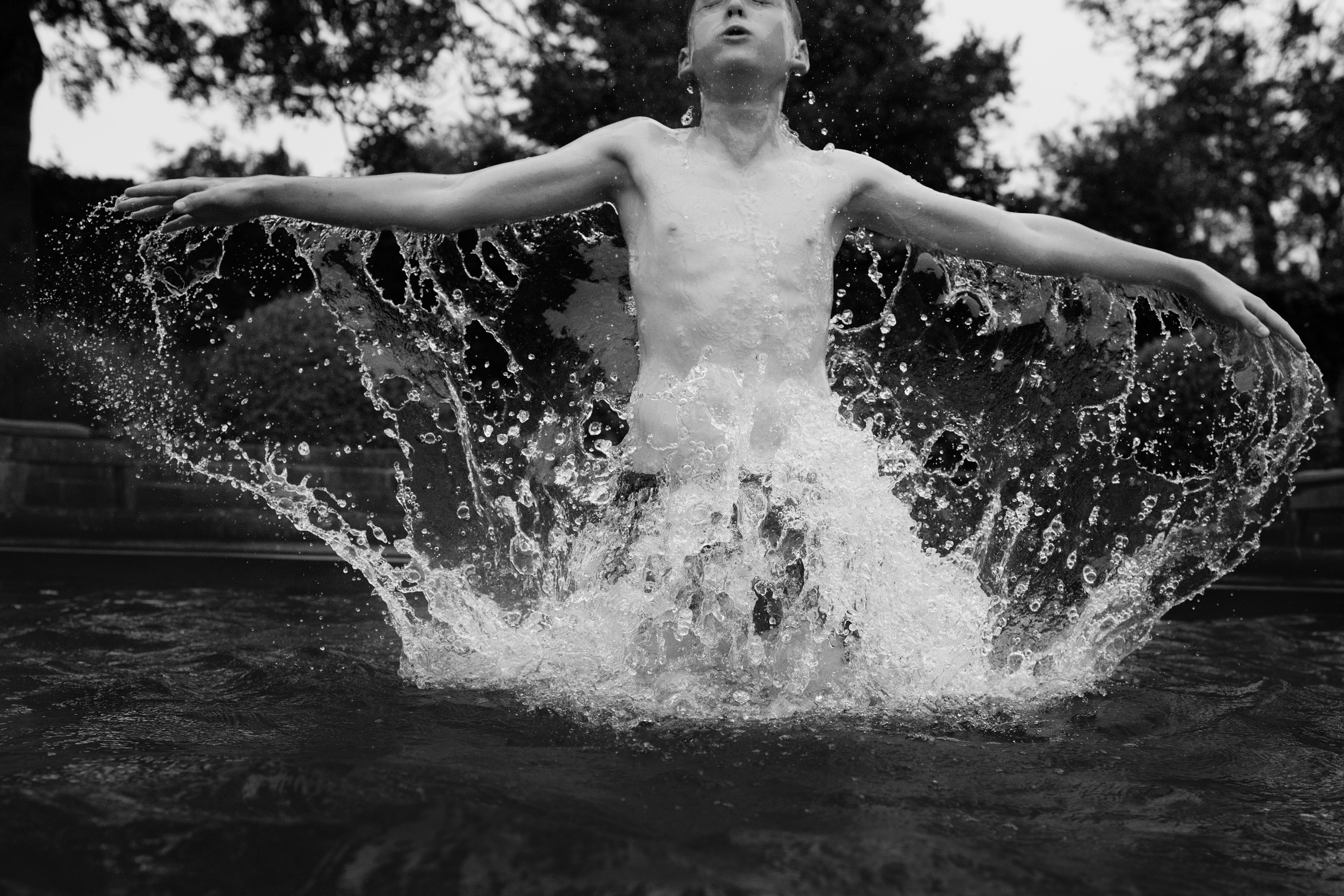 Photograph of a child playing in a pool of water, taken by family photographer Helen Bartlett, one of the speakers on the Canon Spotlight stage at The Photography &amp;amp; Video Show 2026