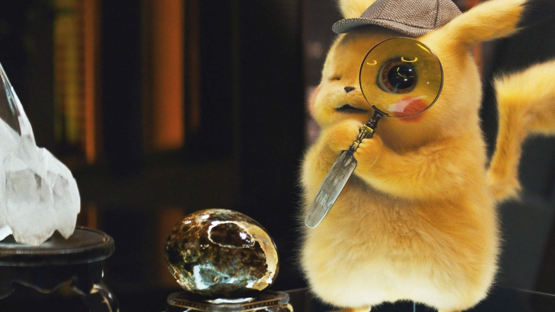 Pikachu holding a magnifying class to his eye during the live-action movie Detective Pikachu.