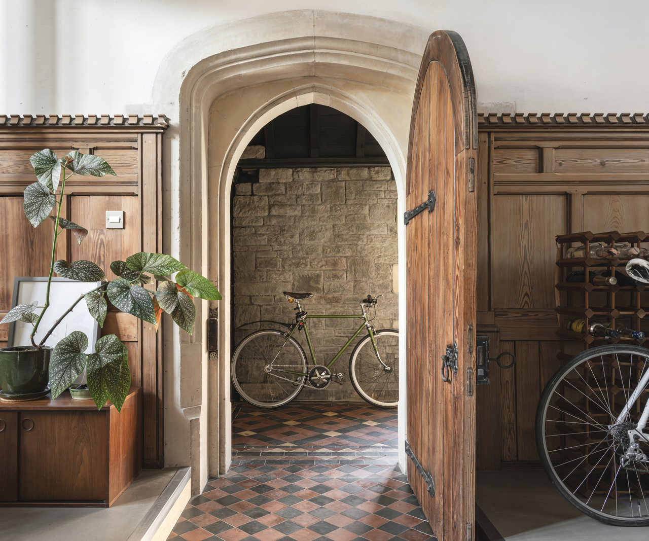 Arched wooden door open with a bike behind it
