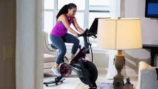 woman working out on an exercise bike in her living room