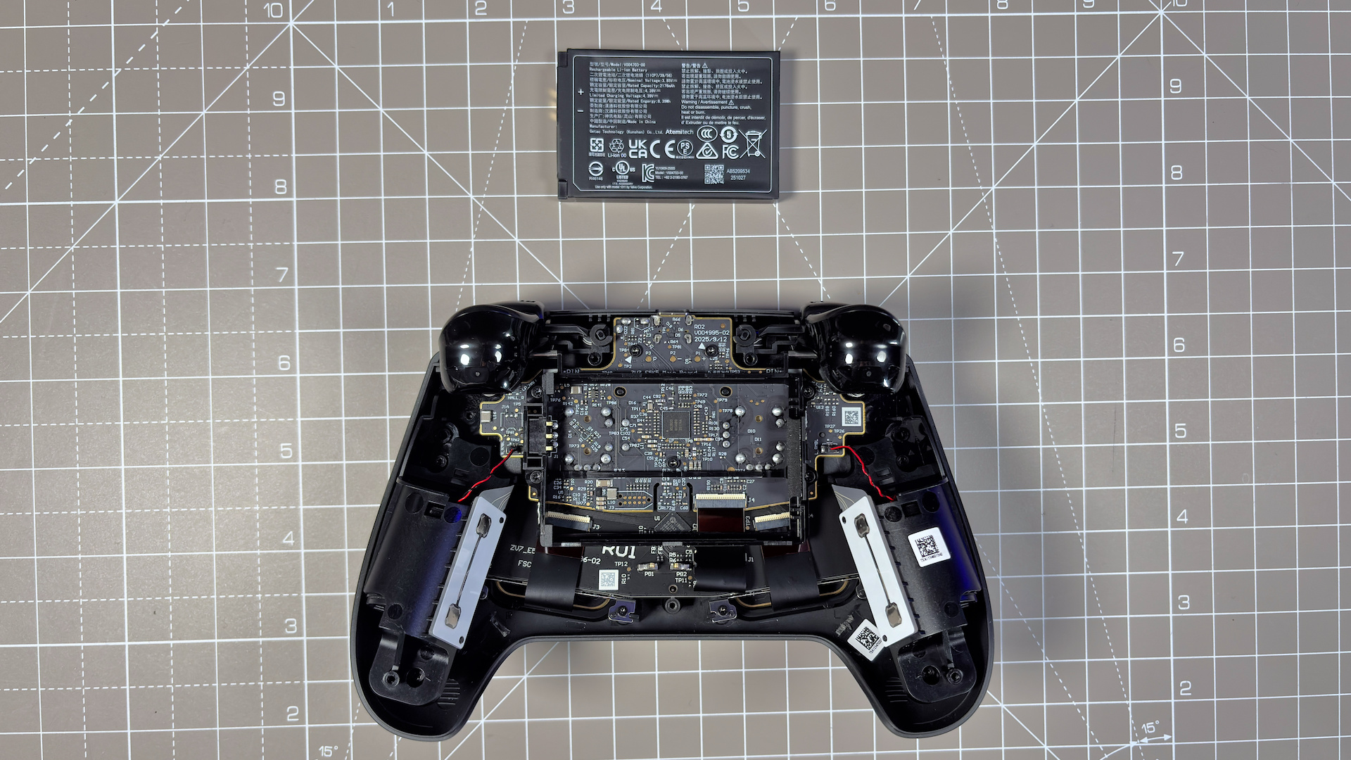 The Steam Controller on a desk during a teardown, with various parts removed.