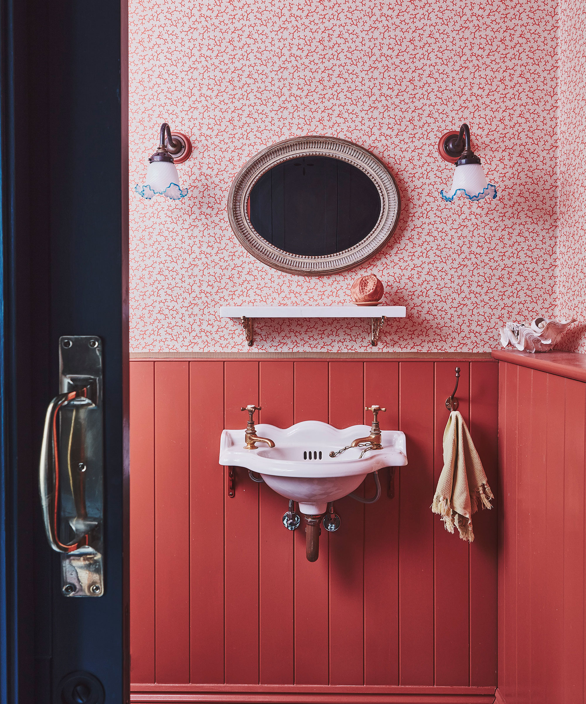 small bathroom with red wall panelling and patterned red and white wallpaper