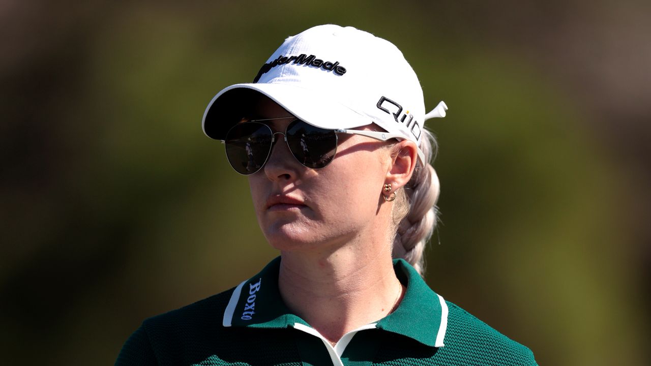 Charley Hull wears a white cap and sunglasses during the 2024 Annika