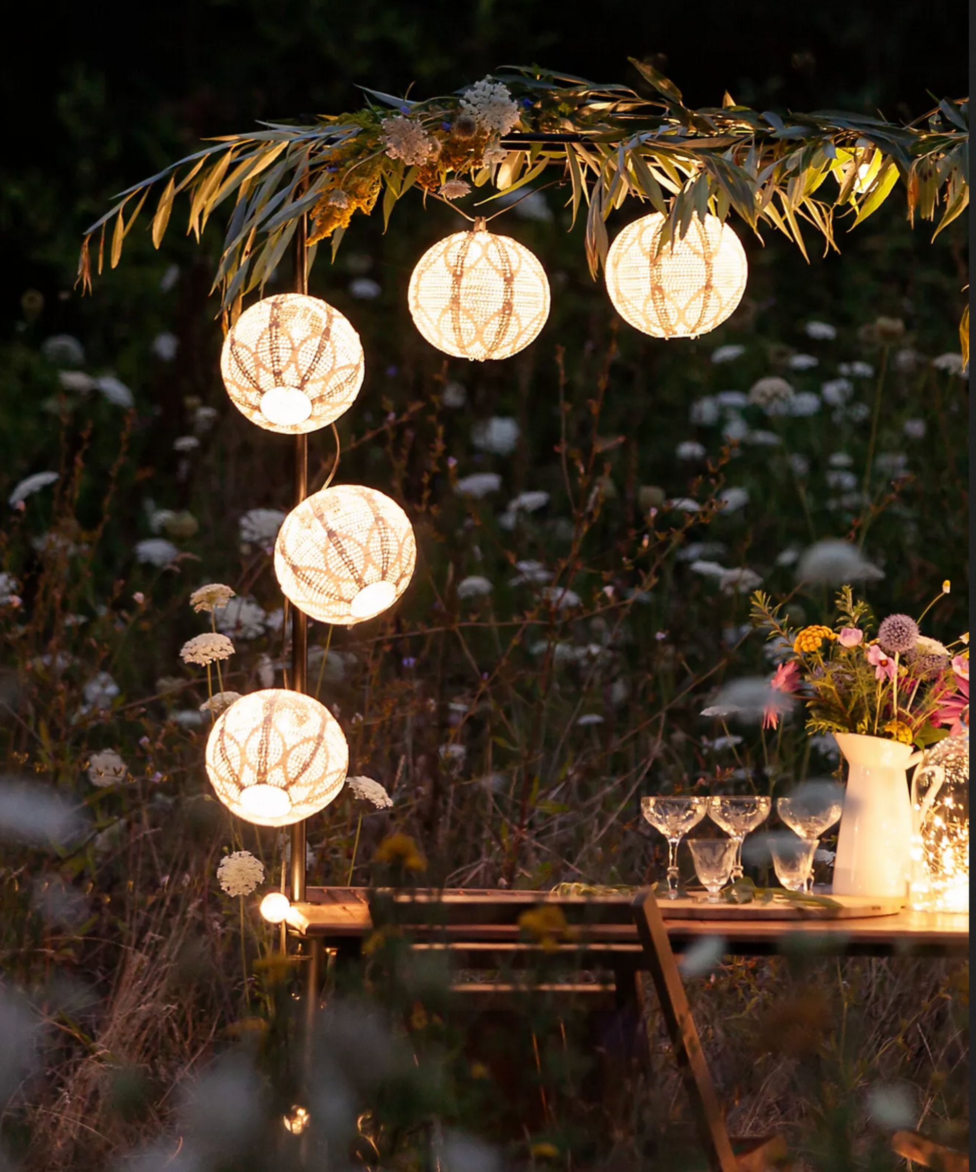 Table with glasses lit up by lanterns