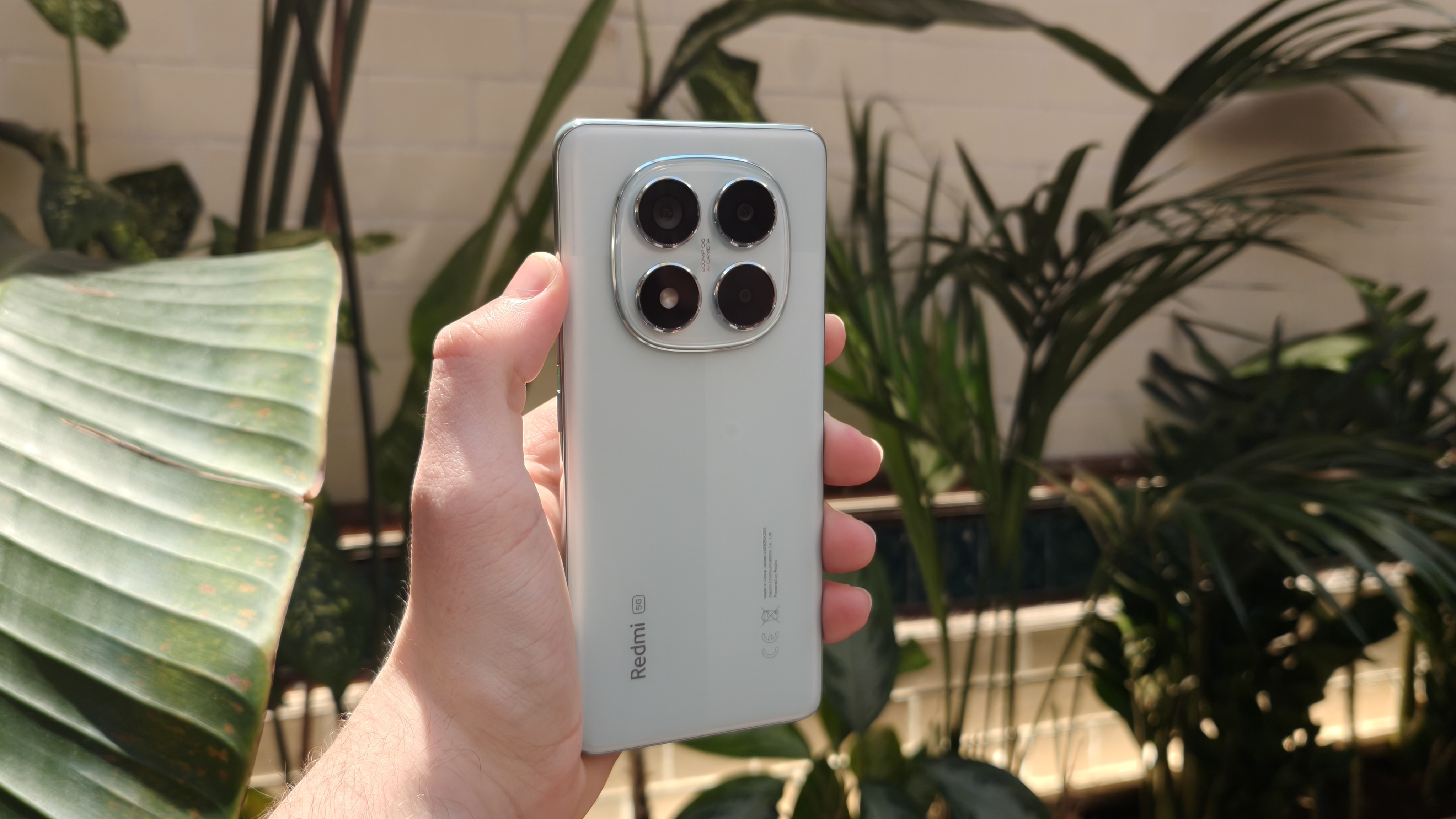 The Redmi Note 14 Pro against a houseplant