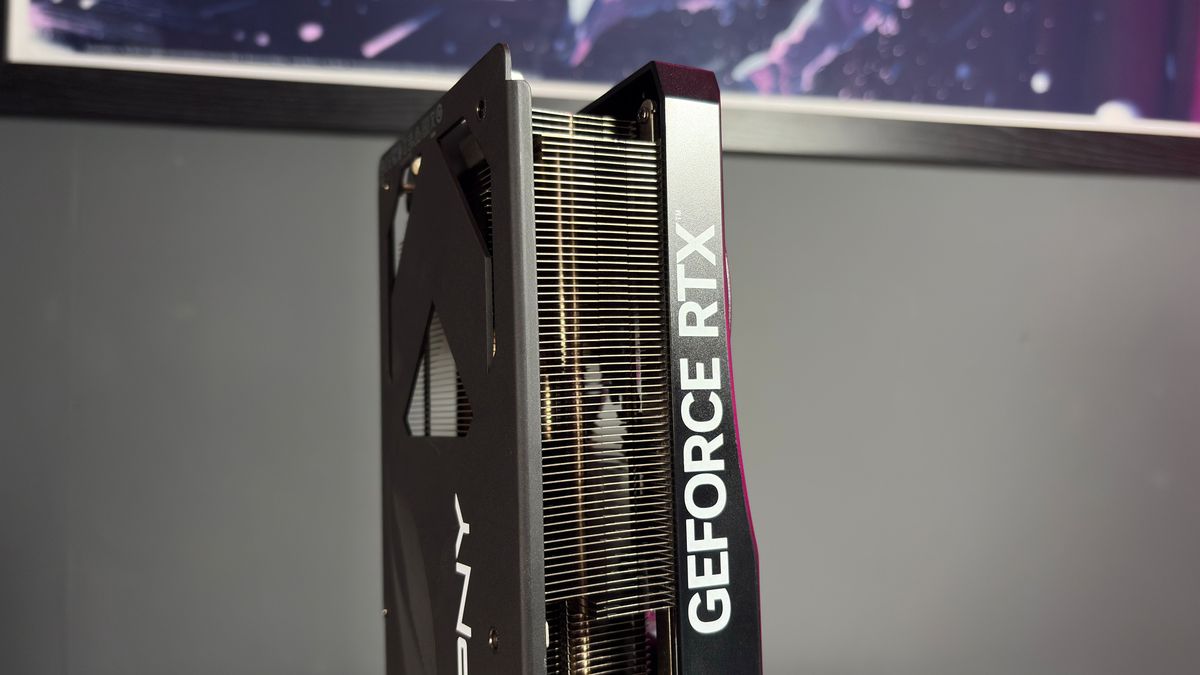 A PNY RTX 5070 Ti OC graphics card on a desk with a desk mat and pink light.