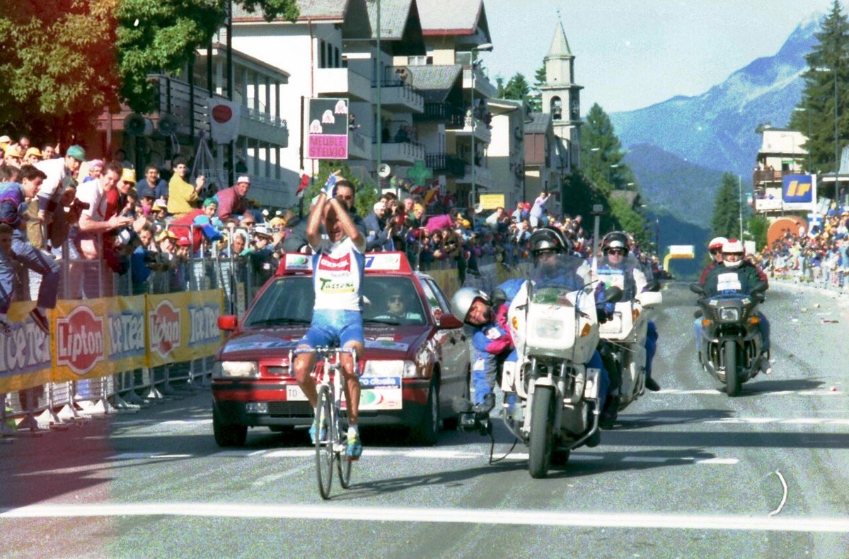 Pantani raises his arms as he crosses the line