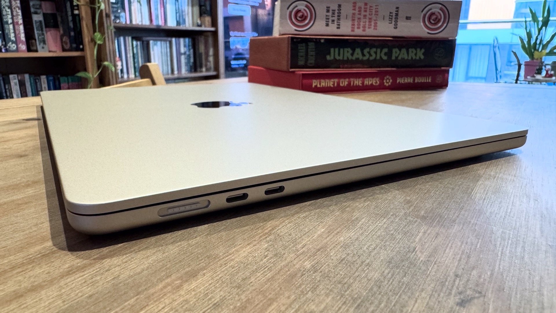 The 2024 MacBook Air M3 on a wooden table in front of a bookshelf.