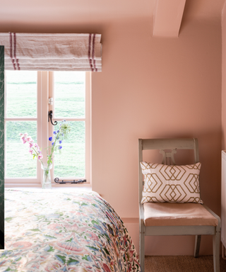 Room painted in setting plaster with single chair and floral bedding in view