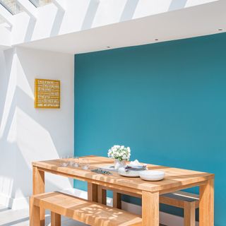 White kitchen with turquoise feature wall and skylight