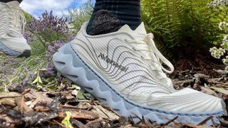 Woman's feet wearing NNormal Tomir trail running shoes