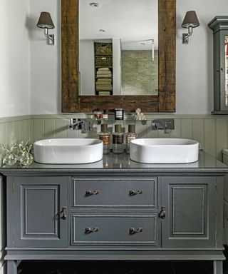 A gray bathroom with a large double vanity unit with drawers and cupboards