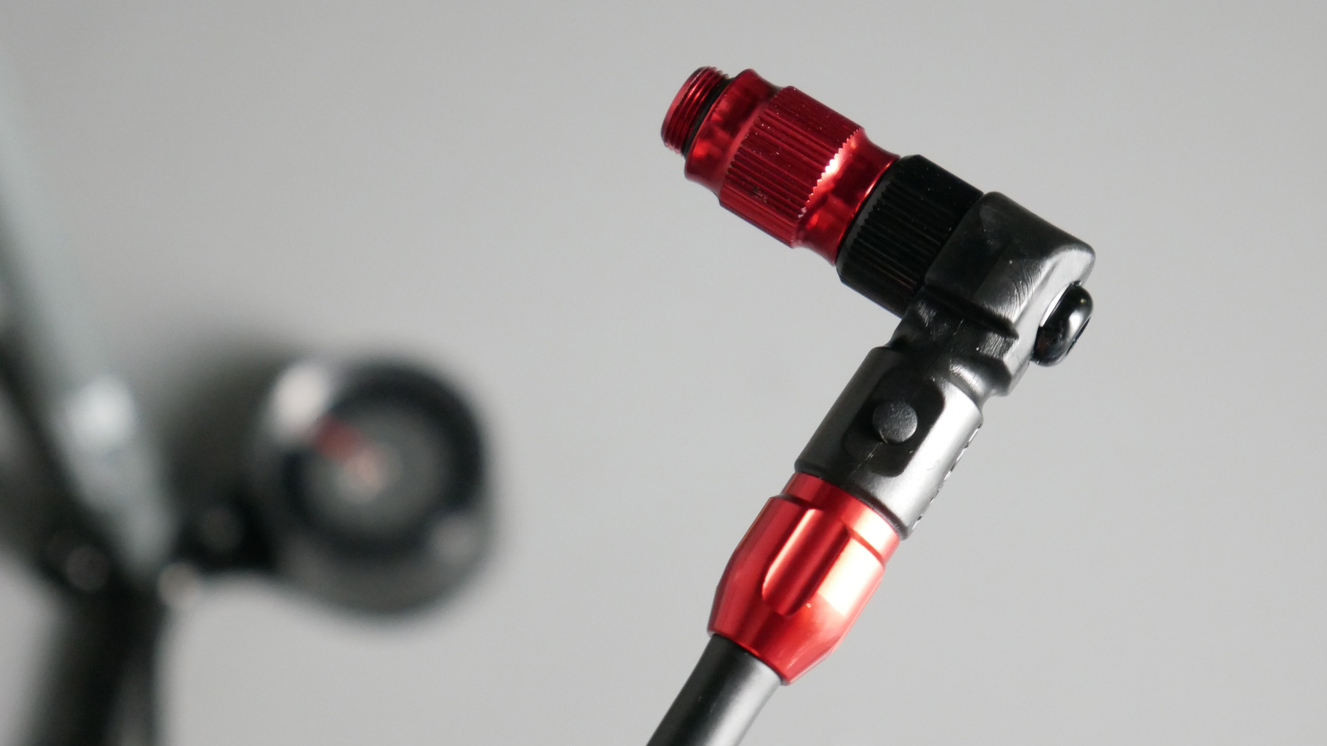 Detailed shot of the Lezyne bike track threaded head, which is anodised red and black