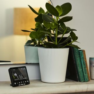 Shelft with plant, books and black smart meter