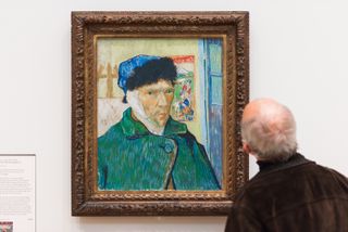 Man looking at a Van Gogh self-portrait