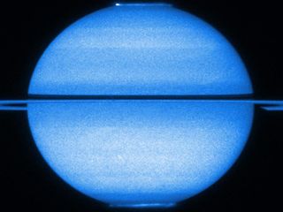 The Hubble Space Telescope shows Saturn with the rings edge-on and both poles in view, with both of its fluttering auroras visible, in early 2009. 