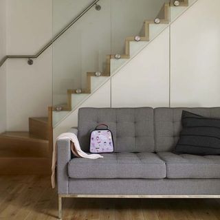 white stairway with wooden flooring and grey sofa set