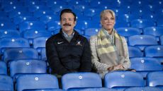 Ted Lasso and Rebecca Walton sit in the stands in Ted Lasso