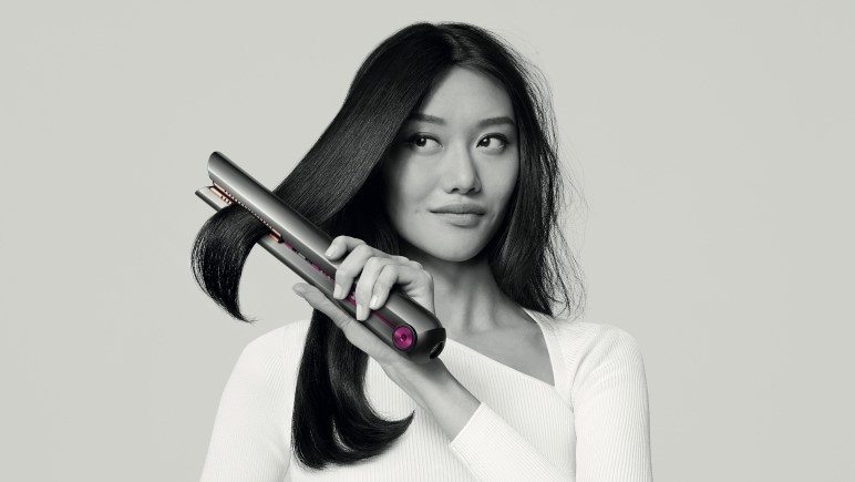 Woman using Dyson Corrale hair straightener