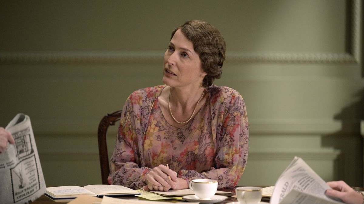 Gillian Anderson as Eleanor Roosevelt in The First Lady seated at a table and wearing a pink floral dress 