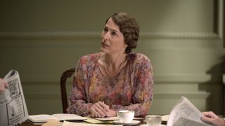 Gillian Anderson as Eleanor Roosevelt in The First Lady seated at a table and wearing a pink floral dress 