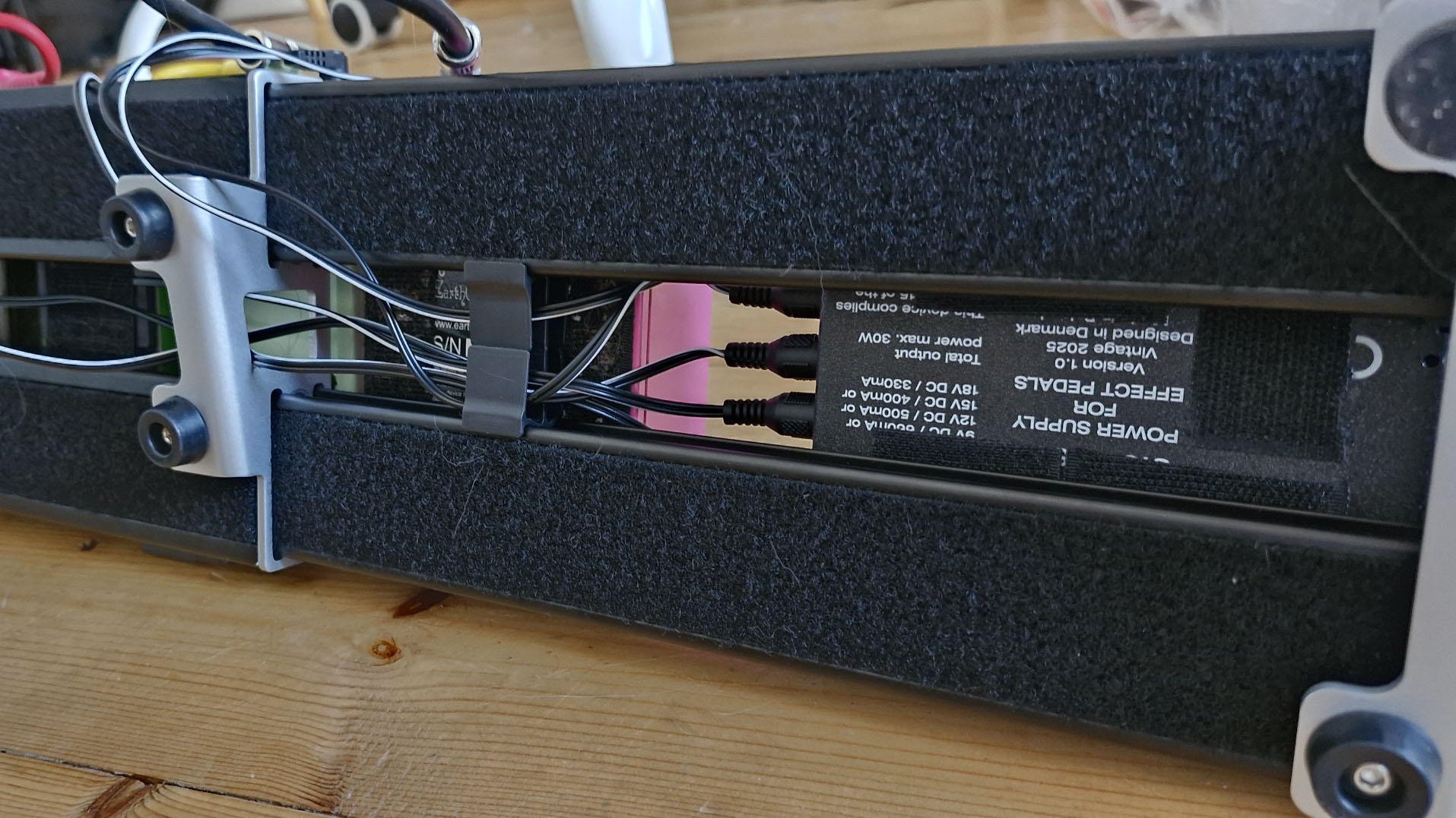 The underside of the Cioks Sol Future Power Generation power supply mounted to a pedalboard