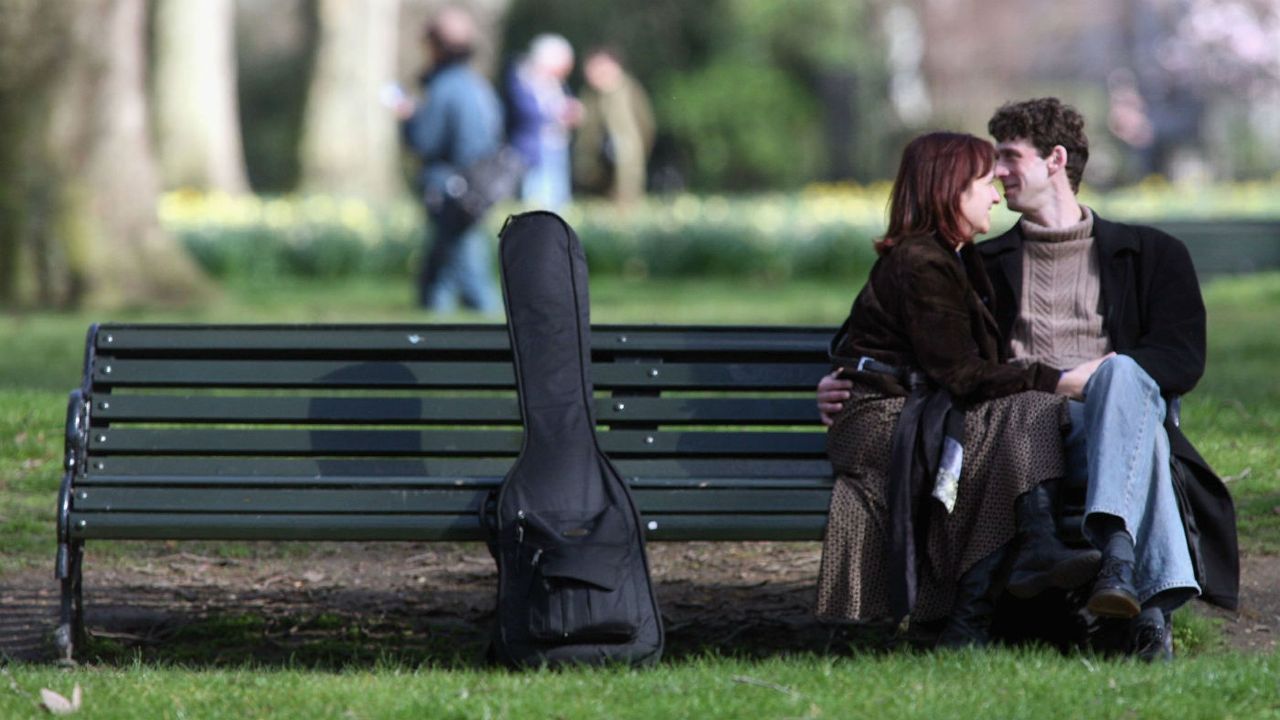 A couple sit on a bench in St James&amp;#039;s Park in London