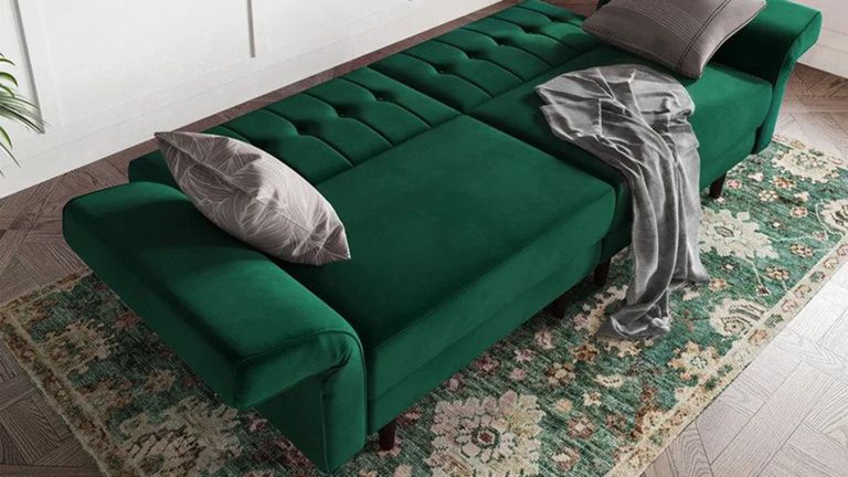 A 3-in-1 green velvet futon that functions as sofa, accent chairs and futon bed decor in living room with area rug underneath