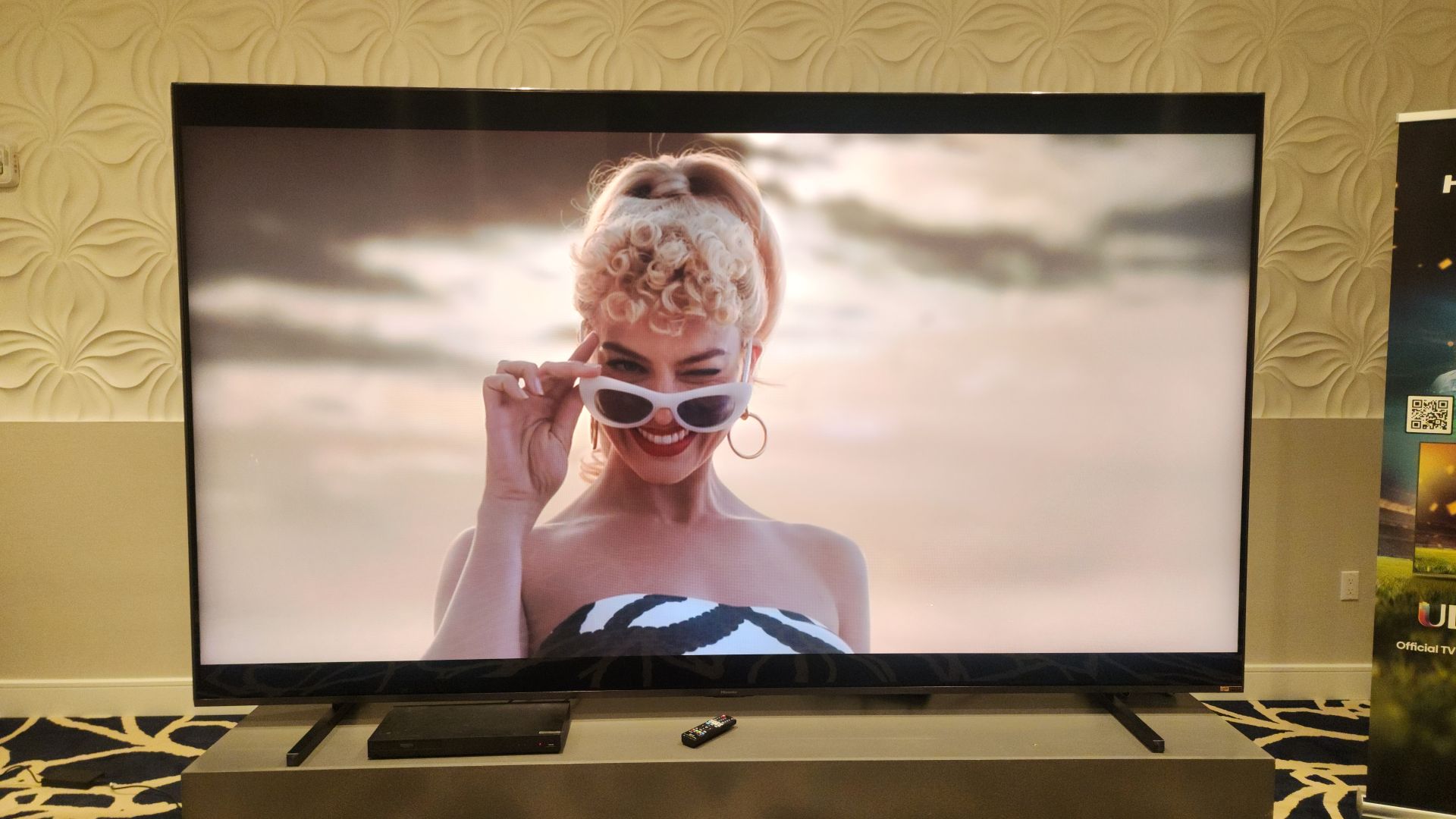 Hisense 116UX showing image of Barbie onscreen