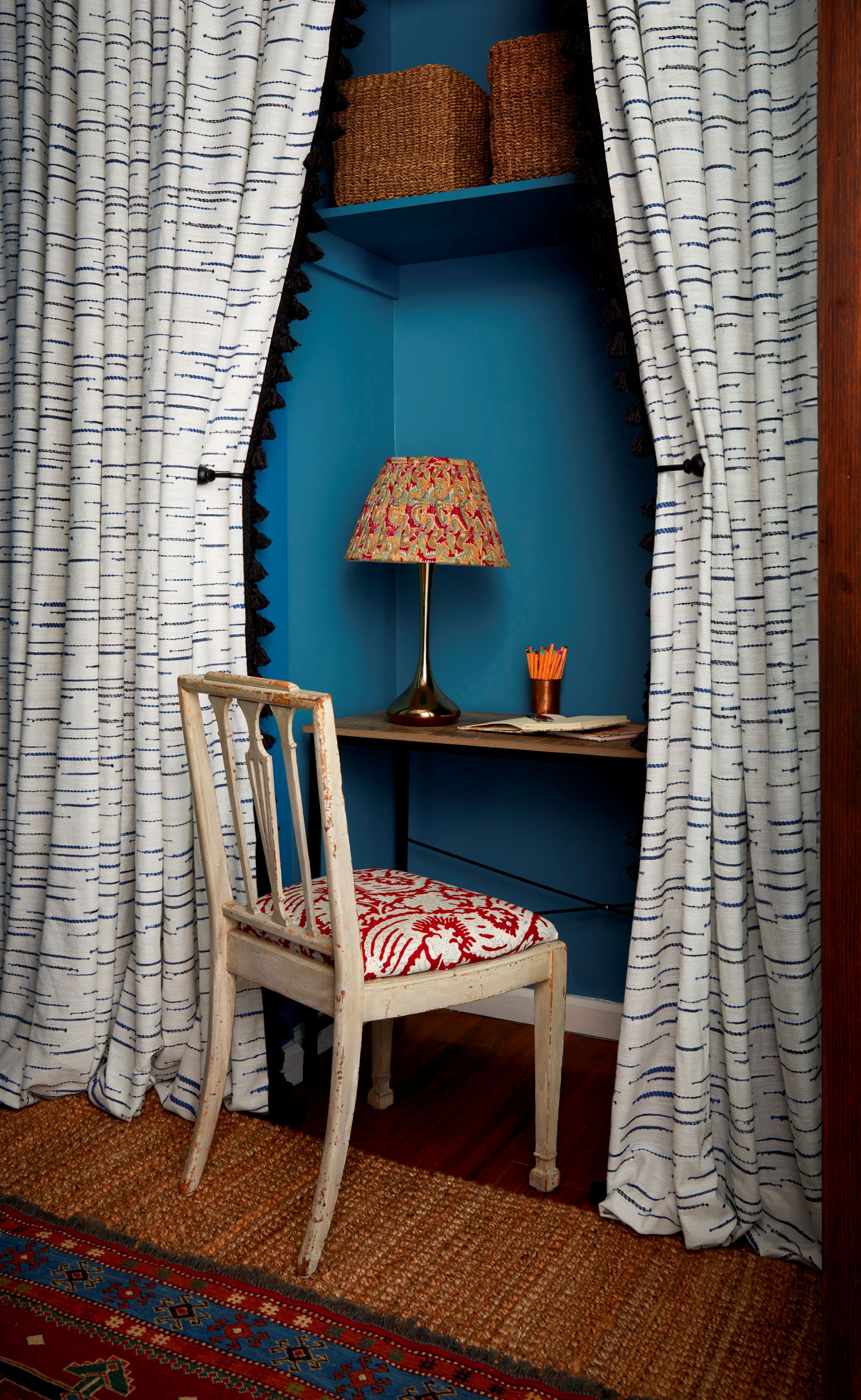 a closet desk framed by dramatic white and gray curtains