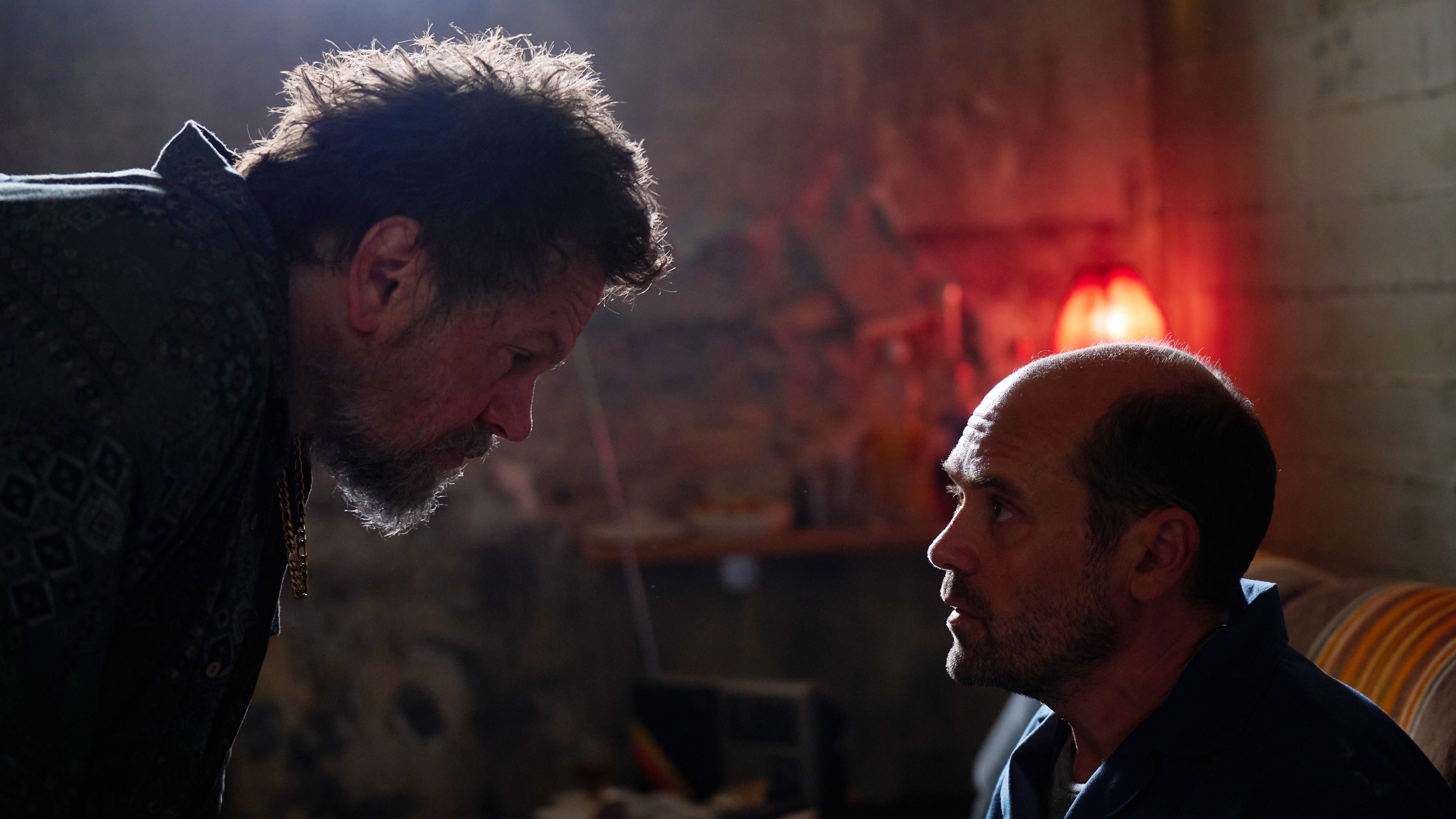 Two men square up to one another in a grotty prison in The Assassin