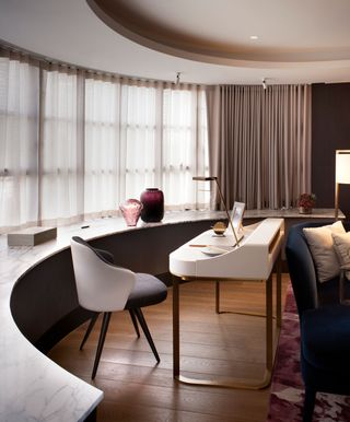 Modern, sleek living room with hidden desk behind sofa arm
