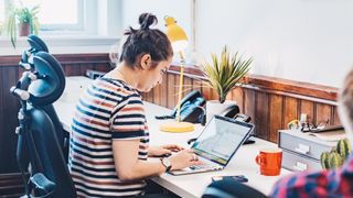 woman sitting at a desk working on a laptop