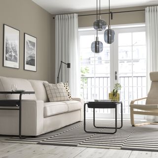 A living room with a striped circular rug, a sofa, and a couch desk in the center of the room