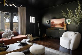 Black living room with white accent chair in the corner
