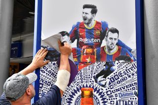 A worker removes an image of Lionel Messi following the Barcelona forward's transfer to PSG in 2021.