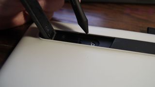 Wacom One pen display with extended leg revealing the pen nib pull ring and extra nibs.