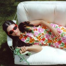 Ariana Greenblatt sitting on sofa wearing floral dress