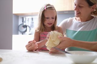 mother and daughter rolling out dough