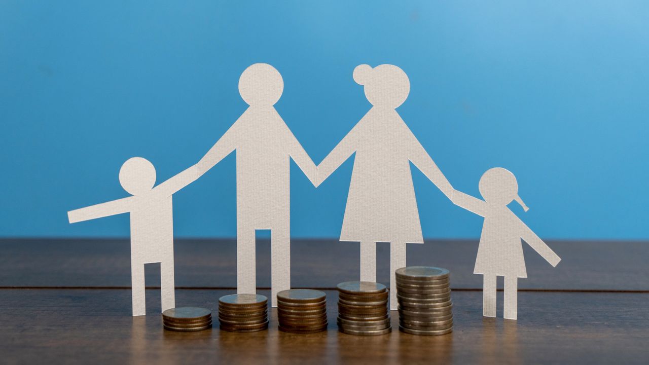 Family paper-cut figure model with money on the table