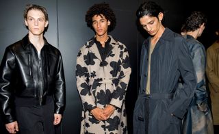 Neil Barrett S/S 2019 - One model wears a long, black leather coat