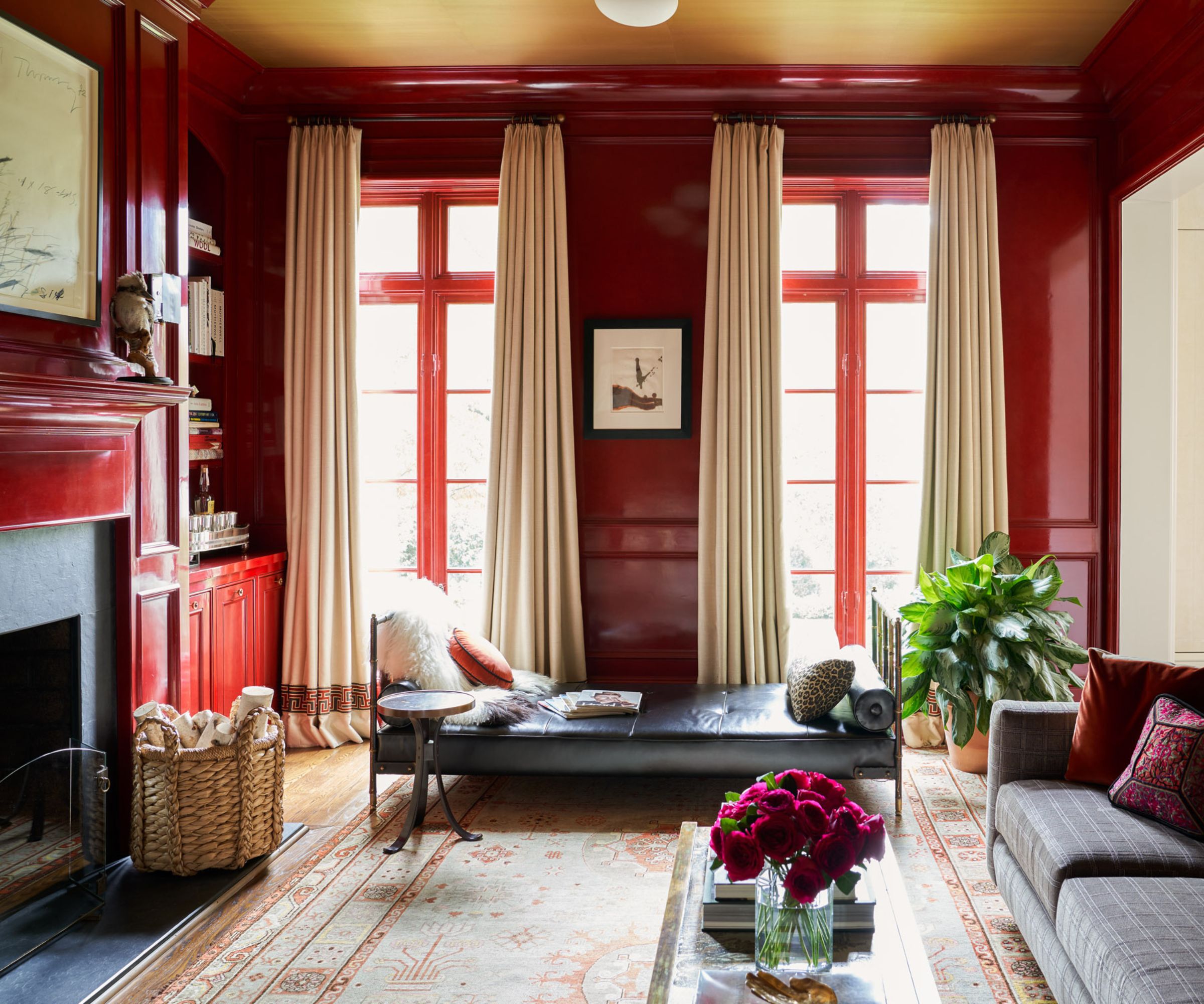 A red living room with color-drenched walls, large French doors and traditional decor.