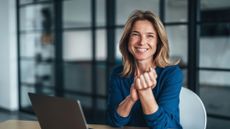 Friendly professional mature woman sitting at a desk in a modern office