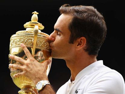 Federer kisses the Wimbledon men’s singles trophy