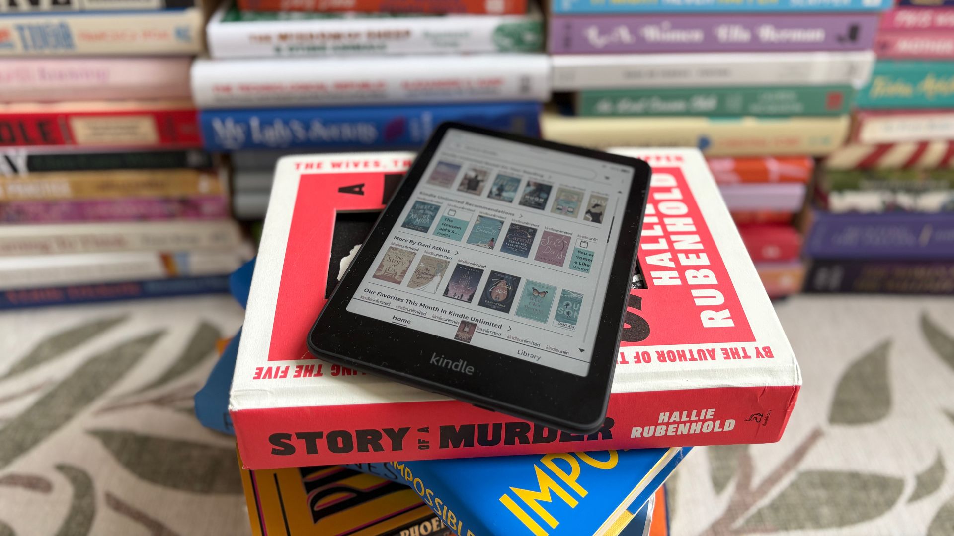 The Kindle Colorsoft with Kindle Unlimited open in front of books