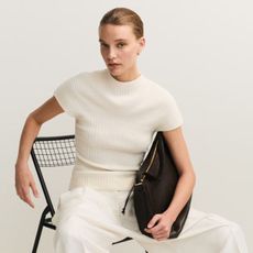 Model wears cream knit top and cream tailored trousers