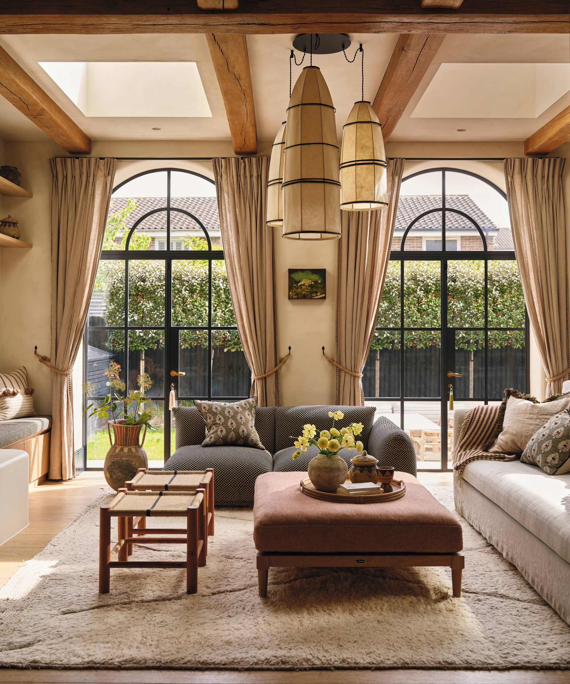 a refined european style living room with large arched crittal doors out to the patio