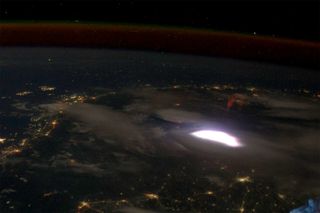 a red sprite and lightning flash captured in an image by astronauts aboard the ISS